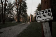 A 'private property, no trespassing' sign on a wooden post along a rural road in Ohio.