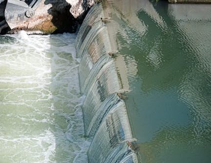 An urban watergate controlling river flow, showing dynamic water movement and engineering design.