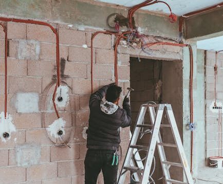 Electrician installing wiring during building renovation in Türkiye.